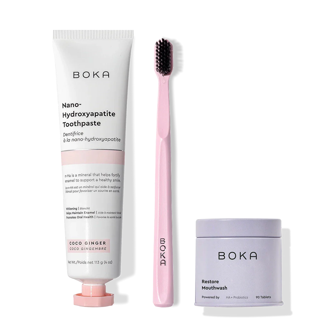 Fresh Faced toothpaste, pink toothbrush with charcoal bristles, and Restore mouthwash tablets on white.