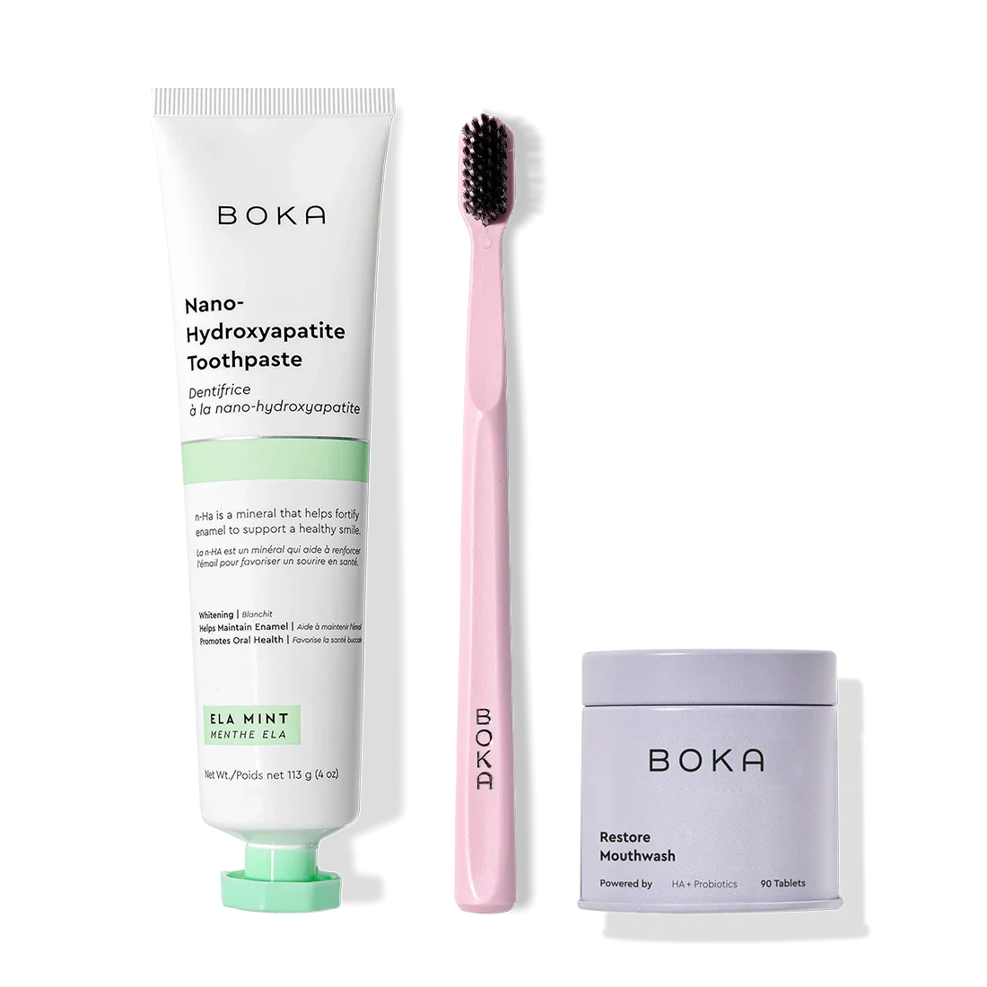 Fresh Faced toothpaste, pink toothbrush with charcoal bristles, and Restore Mouthwash tablets on white.
