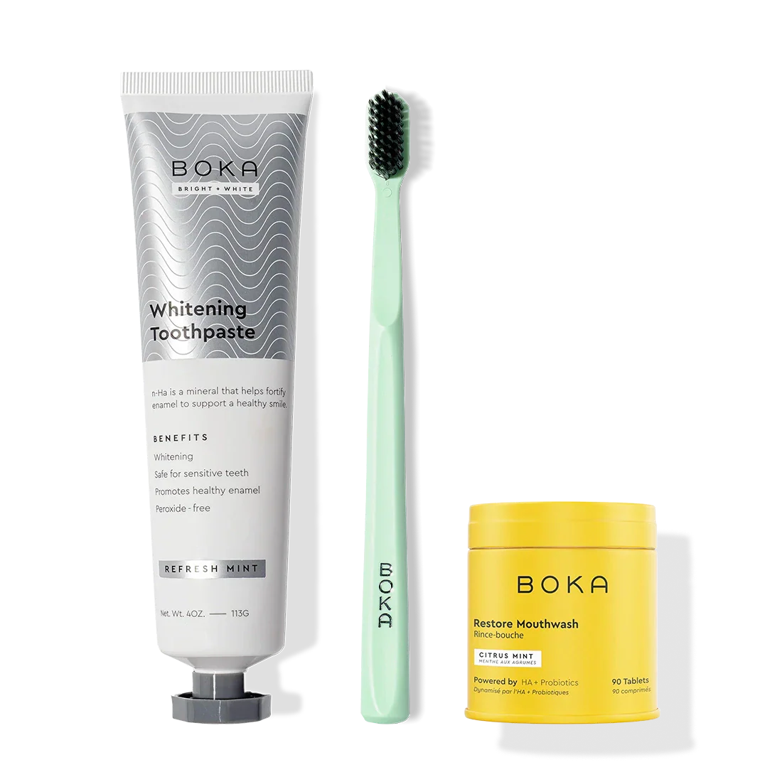 A Fresh Faced toothpaste tube, charcoal bristle toothbrush, and Restore Mouthwash.